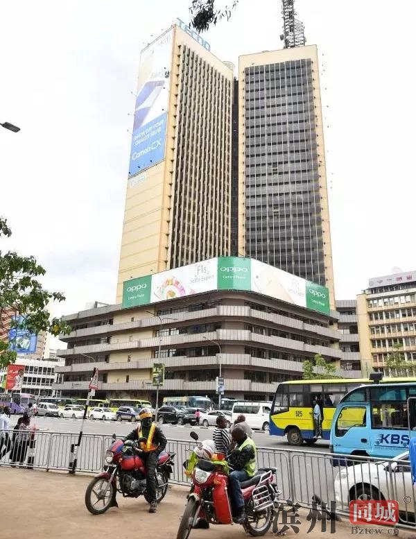 ▲上亿非洲人用上传音手机。图为在肯尼亚首都内罗毕市中心大厦上悬挂的传音手机巨幅广告海报。 （新华社）