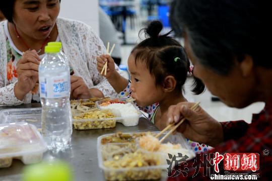 受灾民众在潍坊寿光市营里镇第二初级中学安置点进餐。　梁犇 摄