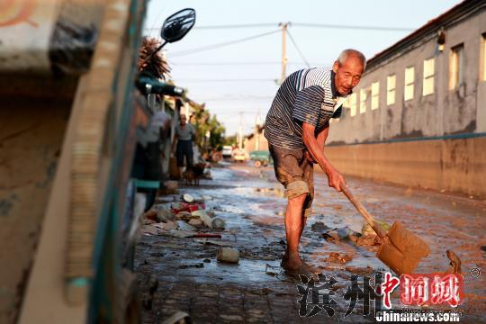 8月24日，洪水退去后潍坊寿光政府组织人员清理街道。潍坊市已启动《重大自然灾害卫生应急预案》最高级别响应。据统计，潍坊市已修复县乡路路基、路面79.14公里，局部损毁桥涵11座；抢通县乡公路22条、143公里。　梁犇 摄